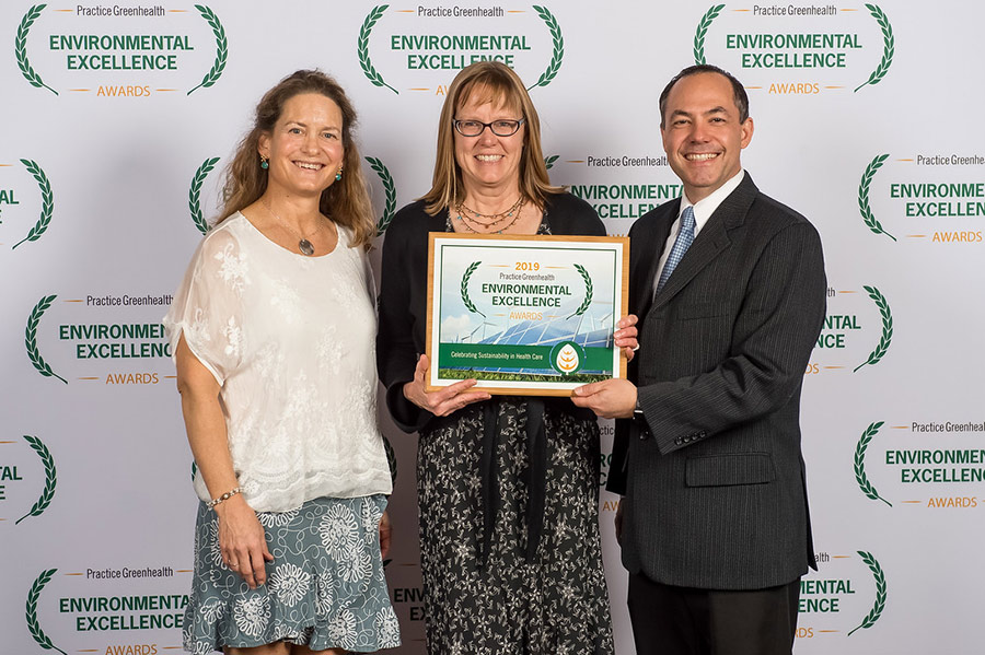 three people accepting environmental excellence award